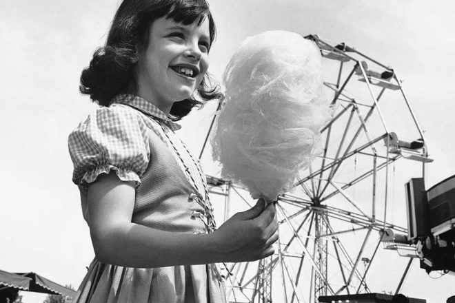 Mädchen mit Zuckerwatte vor Riesenrad (historische Schwarzweißaufnahme) - Deutscher Schaustellerbund e.V.